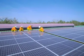Installatore che posa un pannello solare su un tetto residenziale